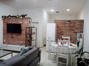 een woonkamer met een tafel en een bakstenen muur bij Sava & Double Rooms in Prijedor