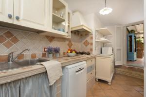 una cucina con mobili bianchi e un lavandino di Villasimius - Villa Sofia a San Stèfano Altre 21 foto