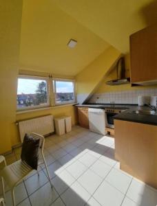 a kitchen with yellow walls and white tile floors at Süße Marie 6 in Karlsruhe