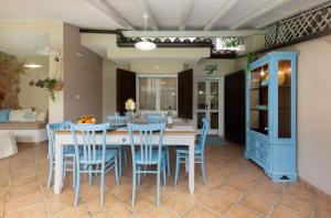 una sala da pranzo con tavolo e sedie blu di Villasimius - Villa Sofia a San Stèfano