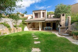 una casa con un prato verde davanti di Villasimius - Villa Sofia a San Stèfano