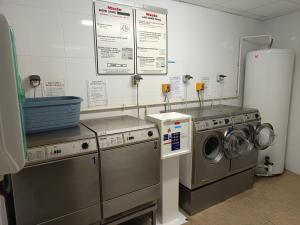 a laundry room with two washing machines and a washer and dryer at Hourquette in Bagnères-de-Bigorre