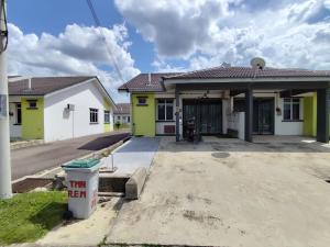 una casa con giallo e bianco di MAM Guesthouse Kota Tinggi a Kota Tinggi