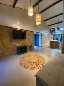 a living room with a flat screen tv and a rug at Flats Elementus Preá in Prea