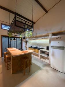 a kitchen with a white refrigerator and a table at Flats Elementus Preá in Prea