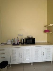 a white cabinet with a microwave on top of it at CK Cozy House in Sattahip