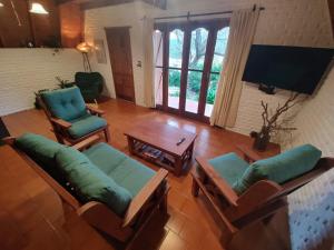 a living room with chairs and a table and a tv at Welpen Chapa in Mar del Plata