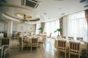 a restaurant with white tables and chairs and windows at Prince in Khust
