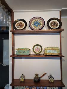 a shelf filled with plates and bowls on a wall at Red Casa in Seogwipo