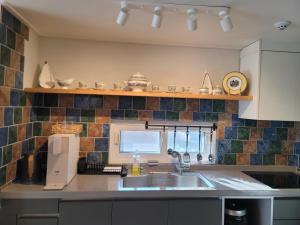a kitchen with a sink and a window at Red Casa in Seogwipo