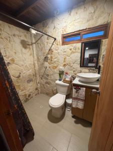 bagno in pietra con servizi igienici e lavandino di Cabaña descanso a Guarne