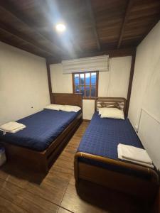 due letti singoli in una stanza con finestra di Cabaña descanso a Guarne