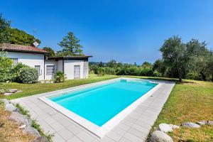 a swimming pool in a yard next to a house at Villa Elisa by Whale Homes in Padenghe sul Garda