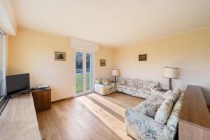 a living room with a couch and a tv at Villa Elisa by Whale Homes in Padenghe sul Garda