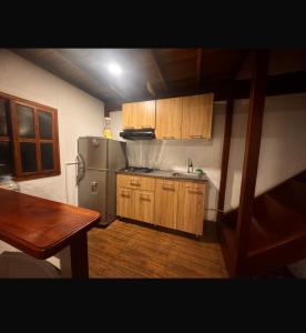 una cucina con frigorifero in acciaio inox e mobili in legno di Cabaña descanso a Guarne