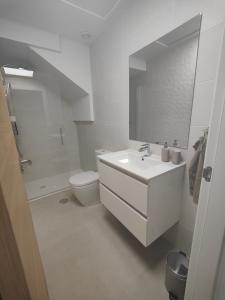 a white bathroom with a sink and a toilet at La Mosa Sol in San Javier