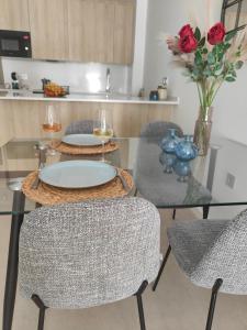 a glass table with two plates and two chairs at La Mosa Sol in San Javier