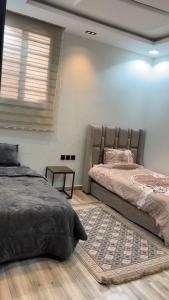 een slaapkamer met 2 bedden en een tapijt bij فيلا راقية وسط المدينة in Az Zulfi