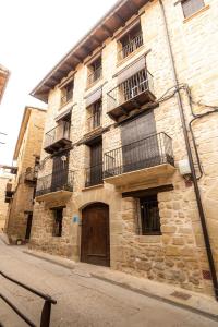 een oud stenen gebouw met balkons in een straat bij Encanto de Valderrobres in Valderrobres