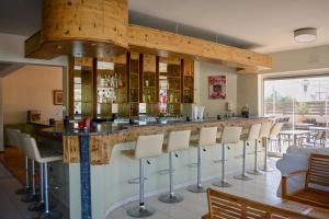 een bar in een restaurant met witte barkrukken bij Ivory Serenity in Theologos