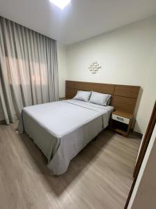 a bedroom with a large bed and a window at quarto standart 2 pousada village in Guarapari