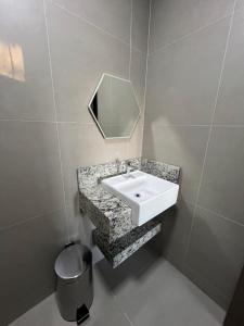 a bathroom with a sink and a mirror at quarto standart 2 pousada village in Guarapari