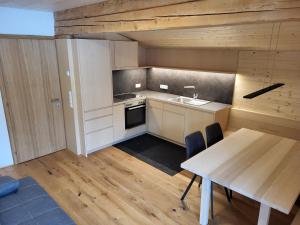 a kitchen with a table and a sink and a stove at Gästehaus Bischof in Damuls