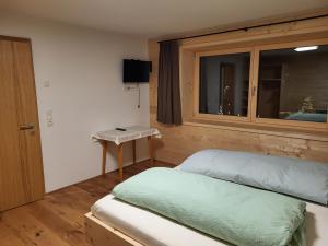 a small bedroom with a bed and a window at Gästehaus Bischof in Damuls