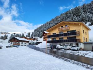 a large building with cars parked in a parking lot at Gästehaus Bischof in Damuls