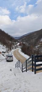 een auto geparkeerd aan de kant van een besneeuwde weg bij Suncani breg in Crni Vrh
