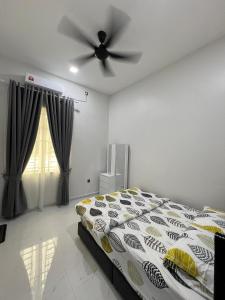 a bedroom with a bed and a ceiling fan at Alaisya Homestay in Kampung Raja