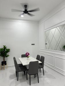 a dining room with a table and a ceiling fan at Alaisya Homestay in Kampung Raja