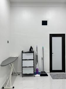 a white room with a shelf and a door at Alaisya Homestay in Kampung Raja +4 photos