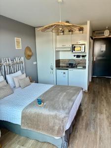 a bedroom with a large bed and a kitchen at Studios Nuitée en Provence in Aix-en-Provence