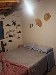a bedroom with a bed with an umbrella on the wall at Vila Borogodó- Casa in Barra Grande