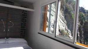a bedroom with a bed and two windows at Affittacamere Elisabetta in Vernazza