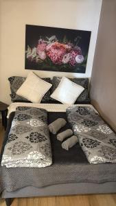 een bed met kussens en een afbeelding van bloemen bij 2 Soul Appart in Dresden +4 foto's