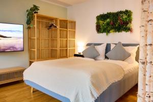 a bedroom with a large bed and a flat screen tv at Großzügiges Studio-Apartment in Dresden