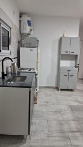 a kitchen with a sink and a stove and refrigerator at Departamento Tunuyan in Monte Hermoso