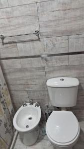 a bathroom with a white toilet and a sink at Departamento Tunuyan in Monte Hermoso