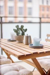 a wooden table with two cups and a cactus at Großzügiges Studio-Apartment in Dresden
