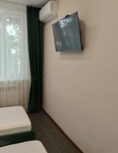 a small room with a tv on the wall at Berloga Hotel in Pavlodar +43 photos