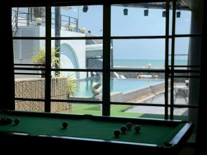 a pool table sitting in front of a window at บ้านดาริน บีช Baan Darlin Beach in Phetchaburi