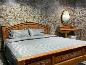 a bedroom with a wooden bed and a mirror at บ้านดาริน บีช Baan Darlin Beach in Phetchaburi +24 photos