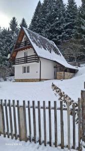 een wit huis met een hek in de sneeuw bij Vikendica Luka in Han Pijesak