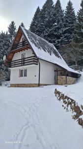 een wit huis met een met sneeuw bedekt dak bij Vikendica Luka in Han Pijesak