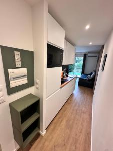 een keuken met witte kasten en een woonkamer bij Ocean et Golf in Anglet