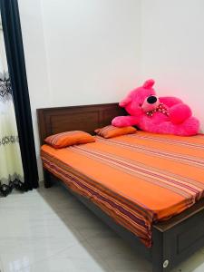 a pink teddy bear sitting on top of a bed at moonlight villa in Weligama