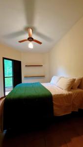 a bedroom with a bed with a ceiling fan at Exelente Localiazação - 50m Enseada e Pitangueiras - Apt Saint Patrick in Guarujá