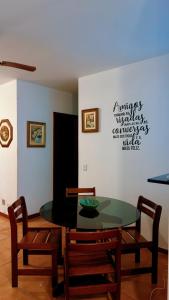 a dining room with a glass table and two chairs at Exelente Localiazação - 50m Enseada e Pitangueiras - Apt Saint Patrick in Guarujá +17 photos